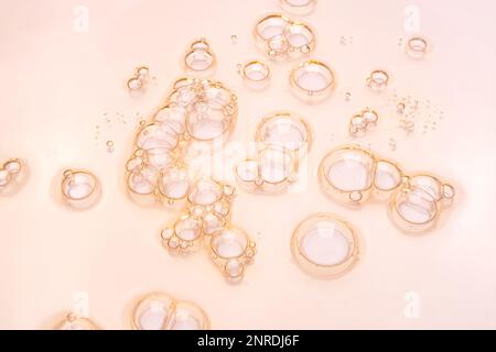 Gel-transparente Textur der kosmetischen Serumölprobe mit Blasenhintergrund auf rosa Stockfoto