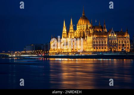 Ungarisches Parlamentsgebäude und Margit Hidd, Margaretenbrücke. Wunderschöne nächtliche Aussicht mit Reflexion auf die Donau, Budapest, Ungarn. Lange Belichtung. Stockfoto