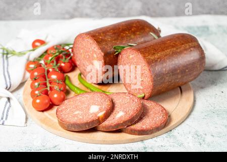 Rinderwurst mit Cheddar. Rohe gegrillte Wurst auf einem Servierbrett aus Holz. Feinkostprodukte Stockfoto