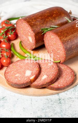 Rinderwurst mit Cheddar. Rohe gegrillte Wurst auf einem Servierbrett aus Holz. Feinkostprodukte. Schließen Stockfoto