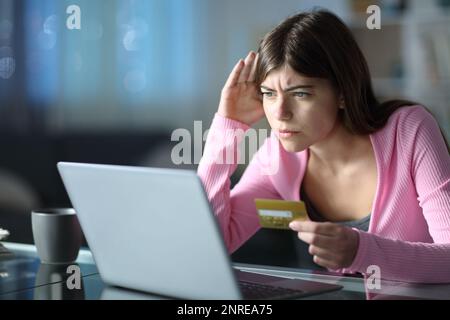 Besorgte Teenager, die Probleme haben, in der Nacht zu Hause online einzukaufen Stockfoto