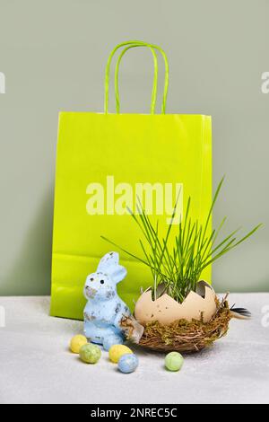 Grüne Einkaufstasche, grünes Gras im Osterei, mit Kopierbereich. Online-Shopping für die Feiertage. Symbole, Traditionen. Stockfoto