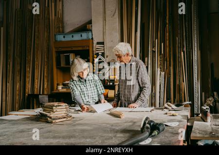 Männliche und weibliche Unternehmer diskutieren während der Zusammenarbeit im Workshop Stockfoto