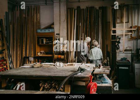 Rückblick auf männliche und weibliche Seniorpreneure, die während der Arbeit im Workshop diskutieren Stockfoto