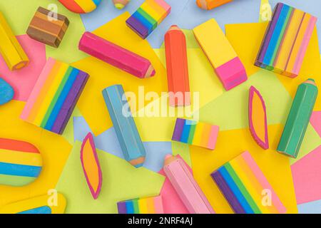 Verschiedene Formen und Farben von Radiergummis auf einem Tisch mit mehrfarbigen Haftnotizen aus Papier auf dem Hintergrund Stockfoto