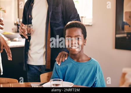Porträt eines glücklichen Jungen mit Vater, der zu Hause Hand an Schulter hält Stockfoto