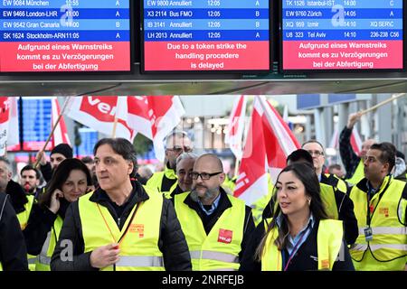 Düsseldorf, Deutschland. 27. Februar 2023. Streikende Flughafenangestellte stehen mit Verdi-Flaggen im Flughafenterminal. Die Gewerkschaft Verdi hat ihre Mitglieder aufgefordert, auf Flughäfen in Nordrhein-Westfalen und im öffentlichen Sektor Warnstreiks zu Unternehmen. Kredit: Federico Gambarini/dpa/Alamy Live News Stockfoto