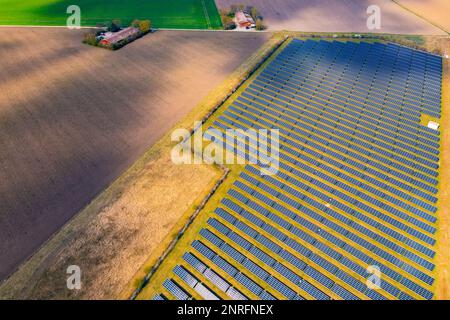 Landwirtschaft und Felder neben Sonnenkollektoren eines Solarparks im ländlichen Deutschland Stockfoto