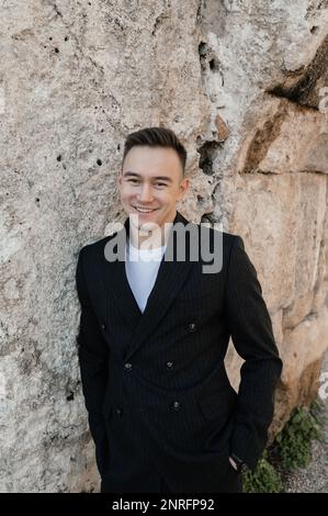 Ein Mann im Anzug, der in der antiken Stadt lacht Stockfoto