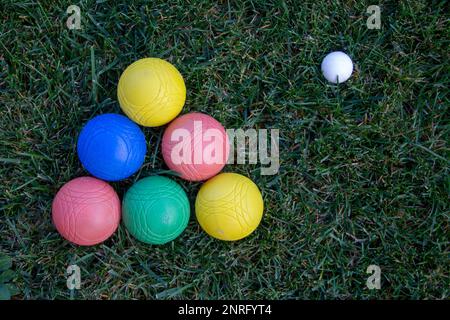 Bild einer Pyramide aus farbigen Schalen in einem grünen Feld mit einem Ball. Stockfoto