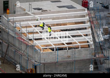 Dachdecker, der einen Bau für einen Lichtschacht auf dem Dach eines Geschäftsgebäudes vorbereitet. Stockfoto