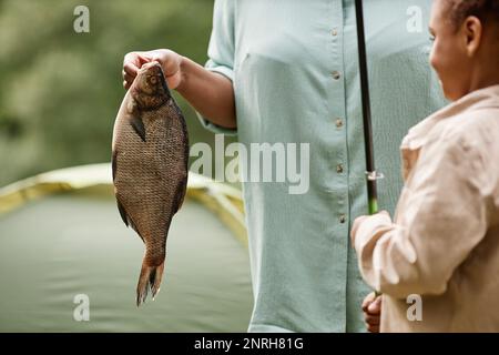 Nahaufnahme von weiblichen Tieren, die während des Angelausflugs mit der Familie im Freien Fische halten, Kopierbereich Stockfoto