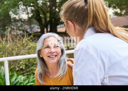 Eine lächelnde Ärztin im Garten eines Pflegeheims Stockfoto