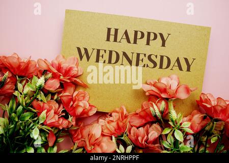 Happy Wednesday Typografie Text mit Blumen auf rosa Hintergrund Stockfoto