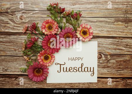 Happy Tuesday Typografie Text mit Blumen auf Holzhintergrund Stockfoto