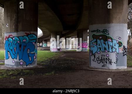 Graffiti auf den Betonstützen unterhalb einer Autobahnüberführung, Glasgow, Schottland, Großbritannien, Europa Stockfoto