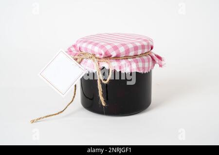 Glas hausgemachter Erdbeermarmelade mit leerem Etikett isoliert auf weißem Hintergrund Stockfoto