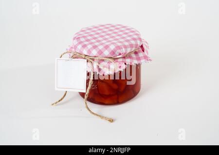 Glas hausgemachter Quittenmarmelade mit leerem Etikett auf weißem Hintergrund Stockfoto