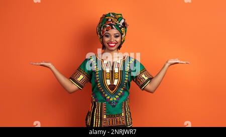 Eine traditionelle afrikanische Frau, die etwas an beiden Händen hält Stockfoto