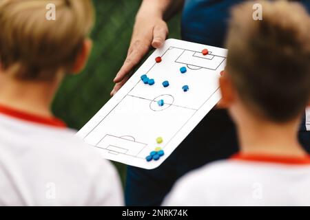 Fußballtrainer hält Taktiken Brett Fußball Taktiken Brett Strategie im Fußball. Kinder Fußball Trainieren. Fußballteam mit Trainer im Stadion Stockfoto