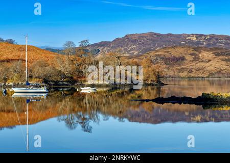 Loch Duich Schottland in orangefarbenen Bracken mit verankerten Yachten, die sich im Sea loch widerspiegeln Stockfoto