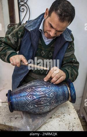 Handwerker bei der Arbeit, die Verzierung eines Schiffes mit Silber filigran, metallhütten Souk, Medina, Meknes. Marokko Stockfoto