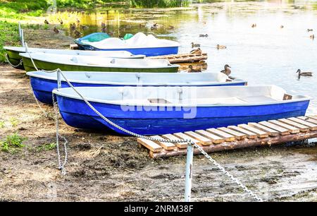 An einem sonnigen Sommertag liegen am Ufer des Sees Vergnügungsboote aus Plastik vor Stockfoto