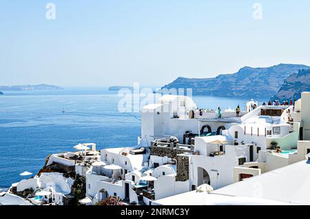 Oía, Santorin, Griechenland; 22. Juni 2022: Blick auf die weißen Häuser und gepflasterten Straßen in den Kykladen. Stadt am südlichen Ägäischen Meer Stockfoto
