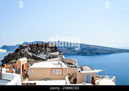 Oía, Santorin, Griechenland; 22. Juni 2022: Blick auf die weißen Häuser und gepflasterten Straßen in den Kykladen. Stadt am südlichen Ägäischen Meer Stockfoto