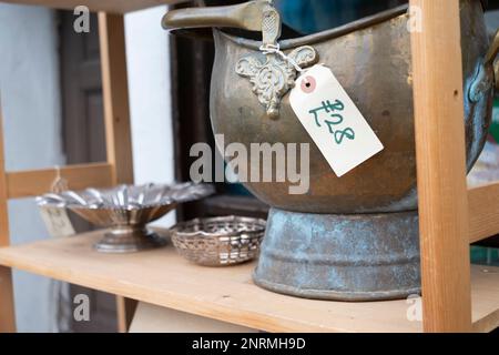 In der Nähe von Ross on Wye, einer Marktstadt in Herefordshire, Großbritannien. Messingkübel zum Verkauf in einem Antiquitätenladen Stockfoto