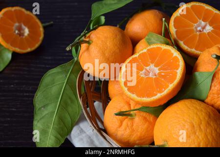 Nahaufnahme frischer und leckerer Mandarinen mit Blättern Stockfoto
