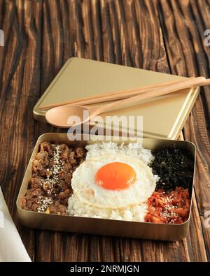 Koreanischer Bulgogi Dosirak mit sonniger Seite Egg und Kimchi. Lunchbox mit Reispackung auf Holztisch Stockfoto