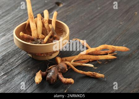 Fingerwurzel auf einem schwarzen Holztisch. Asiatische Kräuter und Gewürze Stockfoto