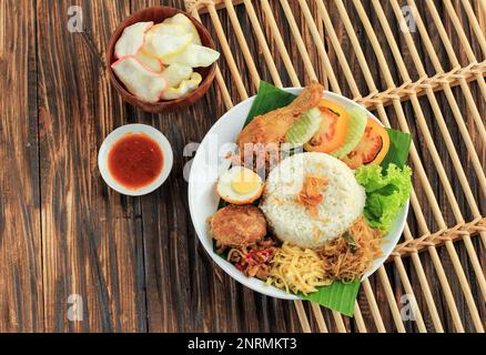 Top Vie Nasi Uduk, typisches indonesisches Frühstück. Gedämpfter Reis, gekocht mit Kokosmilch, serviert mit gebratenem Hähnchen. Eggs, Tempeh Oreg und BiH Stockfoto