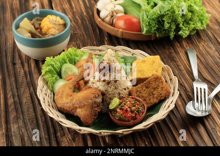 Nasi Tutug Oncom, traditionelles Sundanesisches Gericht, gemischt mit fermentierten Sojabohnenprodukten von Oncom, serviert mit verschiedenen Beilagen Stockfoto