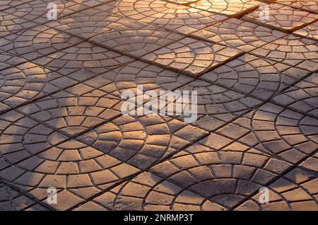 Pflasterplatten liegen fälschlicherweise in Wellen in der Sonne auf einer Straße in Russland Stockfoto