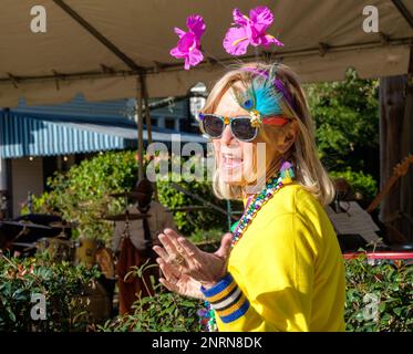 NEW ORLEANS, LA, USA - 18. FEBRUAR 2023: Farbenfrohe Kostümbildnerin, die auf einer Mardi Gras Block Party im Viertel Uptown eine Rede hält Stockfoto