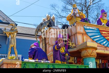NEW ORLEANS, LA, USA - 19. FEBRUAR 2023: Maskierte Floßfahrer mit Krewe of Thoth, die bei der Mardi Gras Parade in der Magazine Street Perlen von einem Floß werfen Stockfoto
