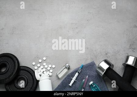 Verschiedene Drogen und Sportgeräte auf grauem Hintergrund, flach liegend mit Platz für Text. Dopingkontrolle Stockfoto