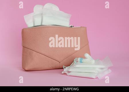 Beutel mit Menstruationseinlagen, Slipeinlagen und Tampons auf pinkfarbenem Hintergrund Stockfoto