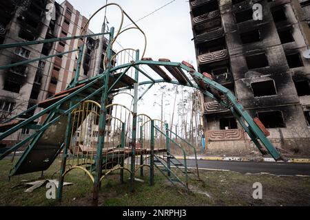 Kiew, Ukraine. 25. Februar 2023. Kiew, Ukraine - 25. Februar 2023: Ein zerstörter Spielplatz vor zerstörten Wohngebäuden in Irpin, nördlich der Hauptstadt der Ukraine, Kiew. (Foto: Kish Kim/Sipa USA) *** Korea out *** Kredit: SIPA USA/Alamy Live News Stockfoto