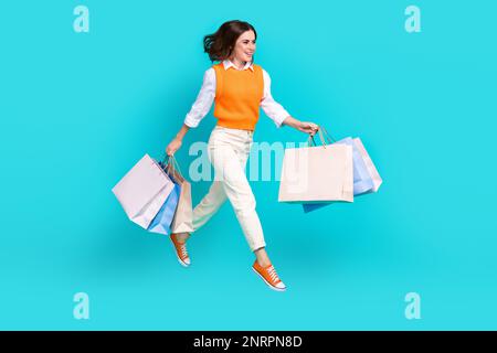 Ganzkörperfoto einer aufgeregten Geschäftsfrau mit Paketen aus der zara New Collection, Rabatt-Aktion isoliert auf aquamarinfarbenem Hintergrund Stockfoto