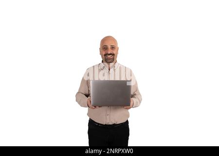 Porträt eines weißen Kerls mit modernem Laptop. Lächelnder, selbstbewusster Geschäftsmann im Stehen, isolierter weißer Hintergrund. Sportlich, männlich mit kahlem Bart. Stockfoto