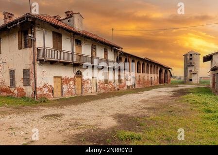 Altes verlassenes Bauernhaus mit typischer ländlicher Architektur des Po-Tals in der Provinz Cuneo, Italien. Ländliche Wohnung mit Stall und Scheune unter br Stockfoto