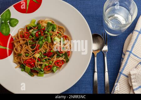 Vegane Pasta zubereitet mit Frühlingszwiebeln und Erbsen, Draufsicht Stockfoto