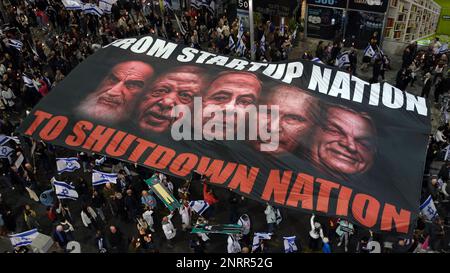 TEL AVIV, ISRAEL - FEBRUAR 25: Regierungsfeindliche Demonstranten singen "Demokratie", da sie ein großes Banner mit einem Porträt von (L-R) dem ehemaligen Obersten Führer des Iran Ruhollah Khomeini, dem ungarischen Premierminister Viktor Orban, dem türkischen Präsidenten Recep Tayyip Erdogan, dem israelischen Premierminister Benjamin Netanjahu, Und der russische Präsident Wladimir Putin während einer Demonstration gegen Israels rechtskräftigen Plan des Justizsystems, der darauf abzielt, den Obersten Gerichtshof des Landes am 25. Februar 2023 in Tel Aviv, Israel, zu schwächen. Zehntausende Kundgebung für die achte Woche in Folge durch Israel gegen die breite Rangin Stockfoto