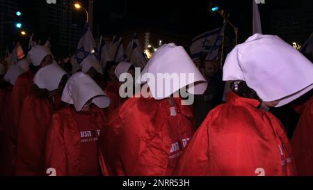 TEL AVIV, ISRAEL - FEBRUAR 25: Dutzende regierungsfeindlicher Demonstranten in langen roten Kleidern und weißen Kopfbedeckungen, Nehmen Sie wie die Magazine im Roman Margaret Atwood „das Magazin der Magd“ an einer Massendemonstration gegen die neue rechtsgerichtete Koalition von Premierminister Benjamin Netanjahu und die vorgeschlagenen gerichtlichen Änderungen Teil, die darauf abzielen, den Obersten Gerichtshof des Landes am 25. Februar 2023 in Tel Aviv, Israel, zu schwächen. Zehntausende Kundgebungen für die achte Woche in Folge in Israel gegen die weitreichende und umstrittene Reform des israelischen Rechtssystems. Stockfoto