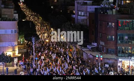 TEL AVIV, ISRAEL - FEBRUAR 25: Regierungsfeindliche Demonstranten halten israelische Flaggen, während sie während einer Demonstration gegen die neue rechtsgerichtete Koalition des israelischen Ministerpräsidenten Benjamin Netanjahu und ihre vorgeschlagenen gerichtlichen Änderungen marschieren, die darauf abzielen, den Obersten Gerichtshof des Landes am 25. Februar 2023 in Tel Aviv, Israel, zu schwächen. Zehntausende Kundgebungen für die achte Woche in Folge in Israel gegen die weitreichende und umstrittene Reform des israelischen Rechtssystems. Stockfoto