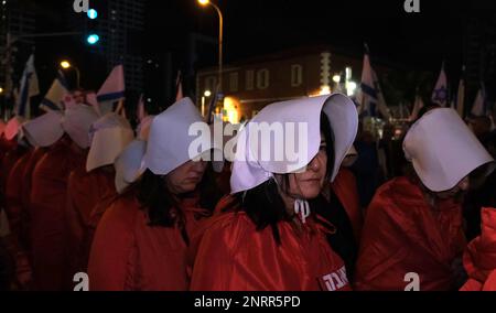 TEL AVIV, ISRAEL - FEBRUAR 25: Dutzende regierungsfeindlicher Demonstranten in langen roten Kleidern und weißen Kopfbedeckungen, Nehmen Sie wie die Magazine im Roman Margaret Atwood „das Magazin der Magd“ an einer Massendemonstration gegen die neue rechtsgerichtete Koalition von Premierminister Benjamin Netanjahu und die vorgeschlagenen gerichtlichen Änderungen Teil, die darauf abzielen, den Obersten Gerichtshof des Landes am 25. Februar 2023 in Tel Aviv, Israel, zu schwächen. Zehntausende Kundgebungen für die achte Woche in Folge in Israel gegen die weitreichende und umstrittene Reform des israelischen Rechtssystems. Stockfoto