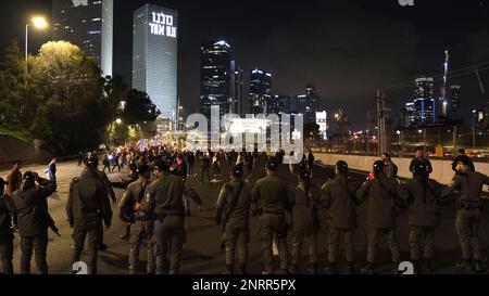 TEL AVIV, ISRAEL - FEBRUAR 25: Mitglieder der israelischen Sicherheit wachen über die demonstranten gegen die Regierung, die die Autobahn von Ayalon blockieren. Eine der wichtigsten Autobahnen Israels während einer Demonstration gegen die neue rechtsgerichtete Koalition von Premierminister Benjamin Netanjahu und ihre vorgeschlagenen gerichtlichen Änderungen, die darauf abzielen, den Obersten Gerichtshof des Landes am 25. Februar 2023 in Tel Aviv, Israel, zu schwächen. Zehntausende Kundgebungen für die achte Woche in Folge in Israel gegen die weitreichende und umstrittene Reform des israelischen Rechtssystems Stockfoto